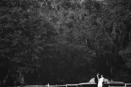 BW image of couple under tree with car